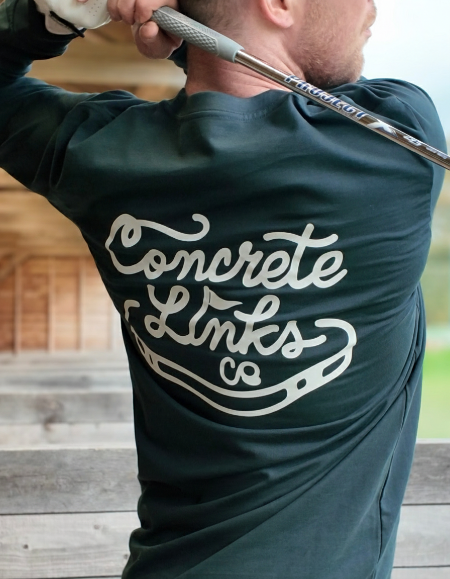 Person wearing a shirt with 'Concrete Links' branding, holding a golf club.