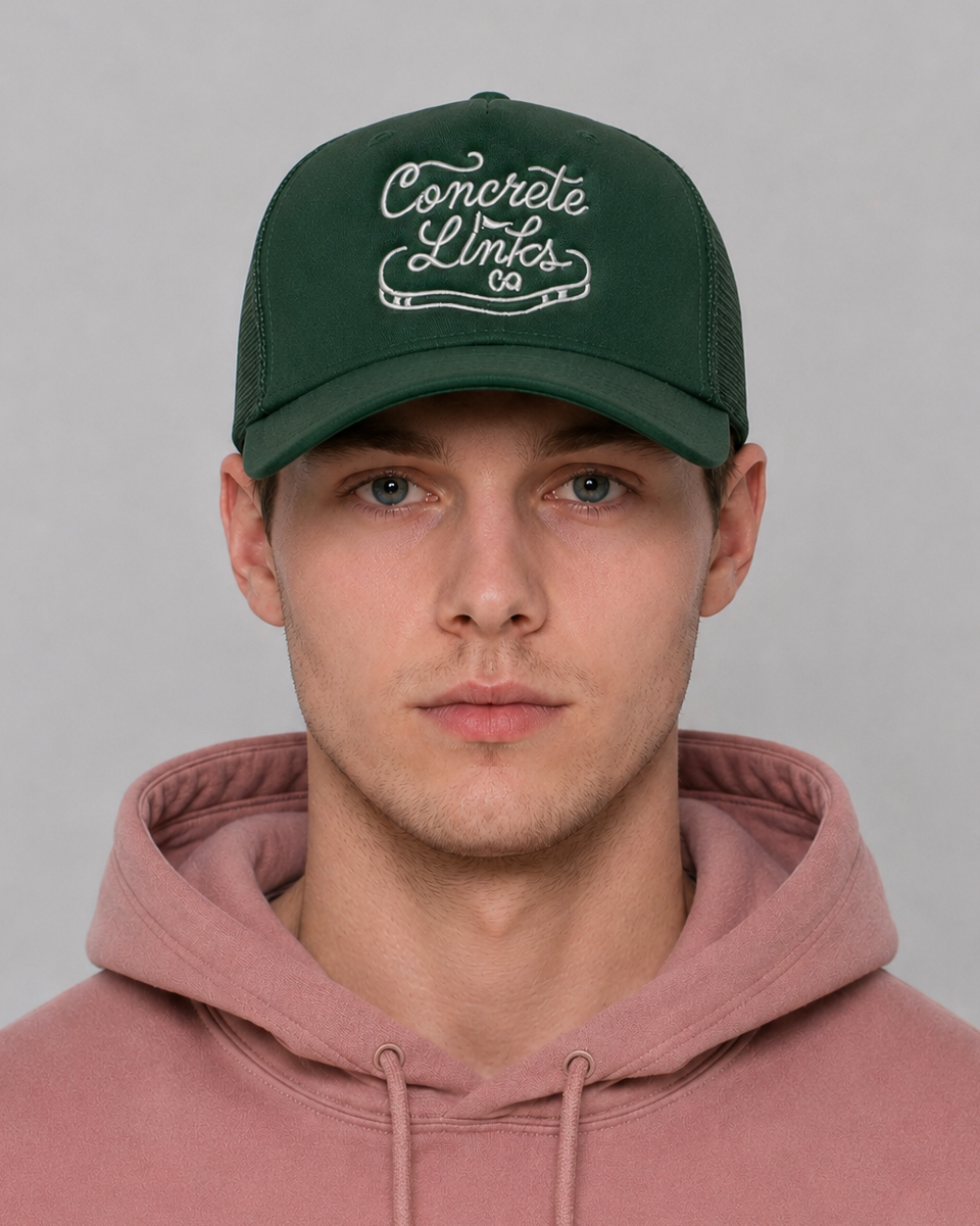 Person wearing a green cap with 'Concrete Links' text and a pink hoodie against a gray background