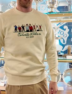 Person wearing a beige sweatshirt with 'Concrete Links Co. EST 2023' design in front of trophies. Ryder Cup

Rory Mcilroy

reed

pavin

Olazabal

Nicklaus

Leonard

Jacklin

Ian Poulter

Golf Ryder Cup

