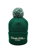 Green beanie with pom-pom on a gray background