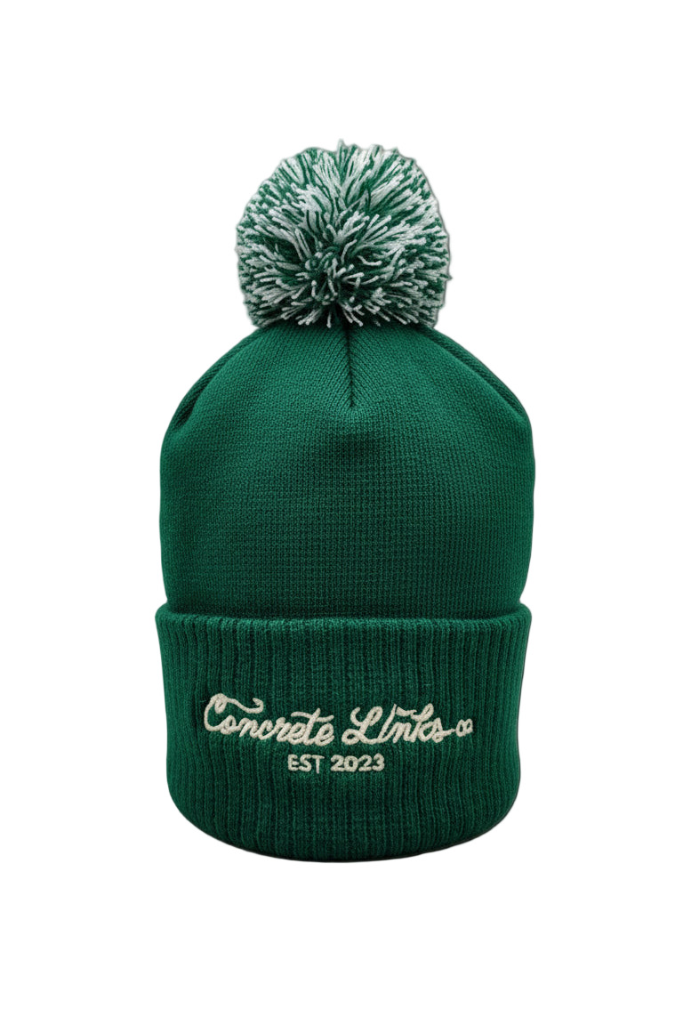 Green beanie with pom-pom on a gray background
