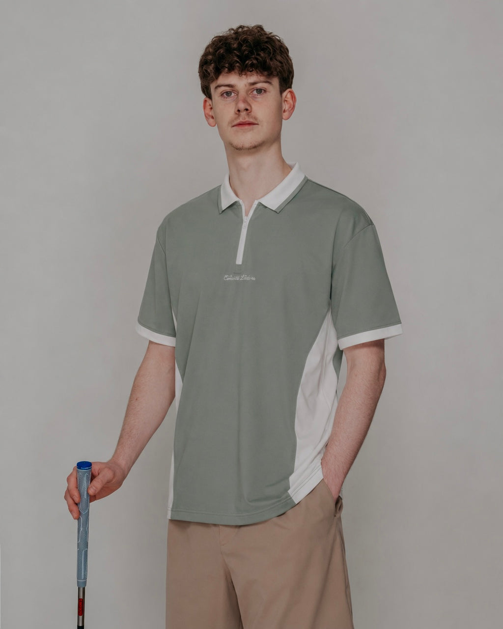Man wearing a green and white polo shirt with a blurred background
