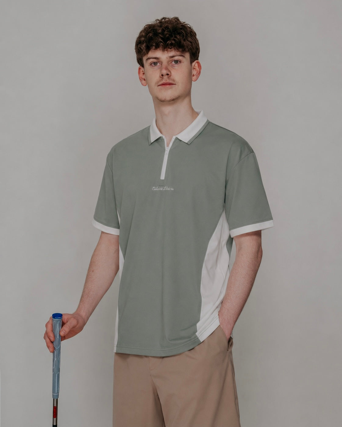 Man wearing a green and white polo shirt with a blurred background